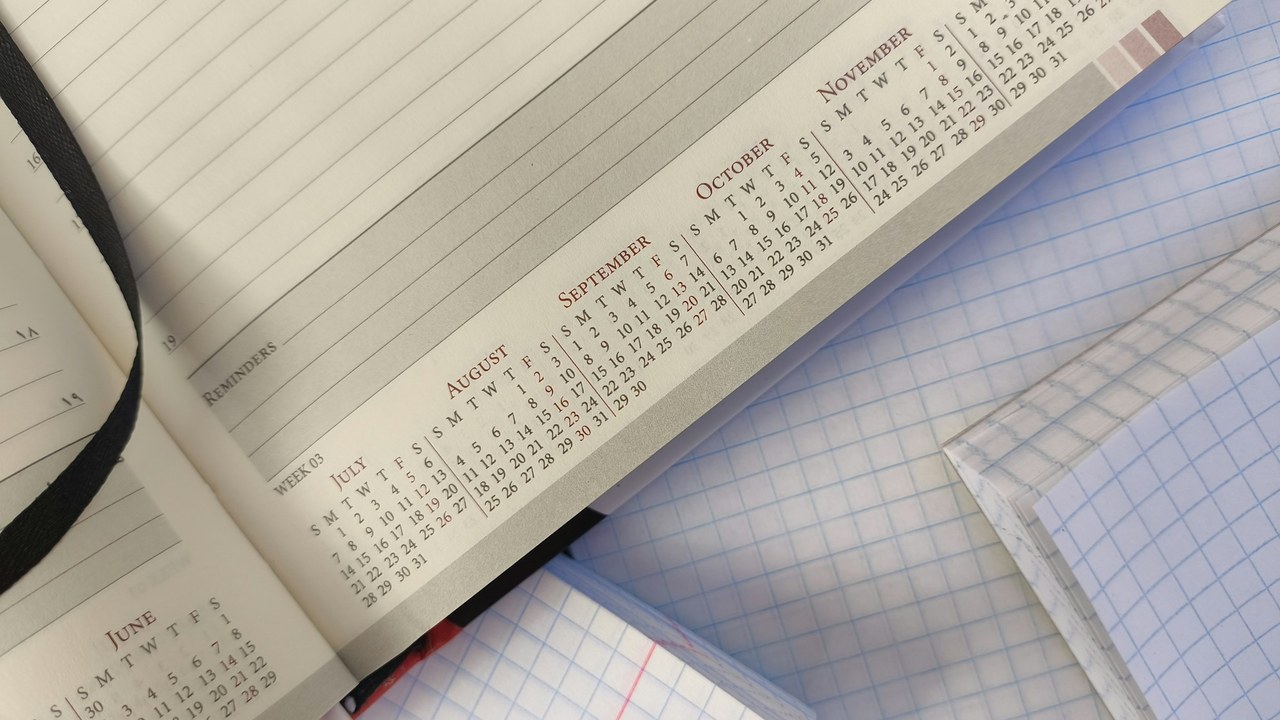An open planner on a page of month-by-month calendars.